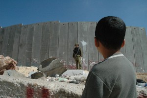 boy_and_soldier_in_front_of_israeli_wall.jpg